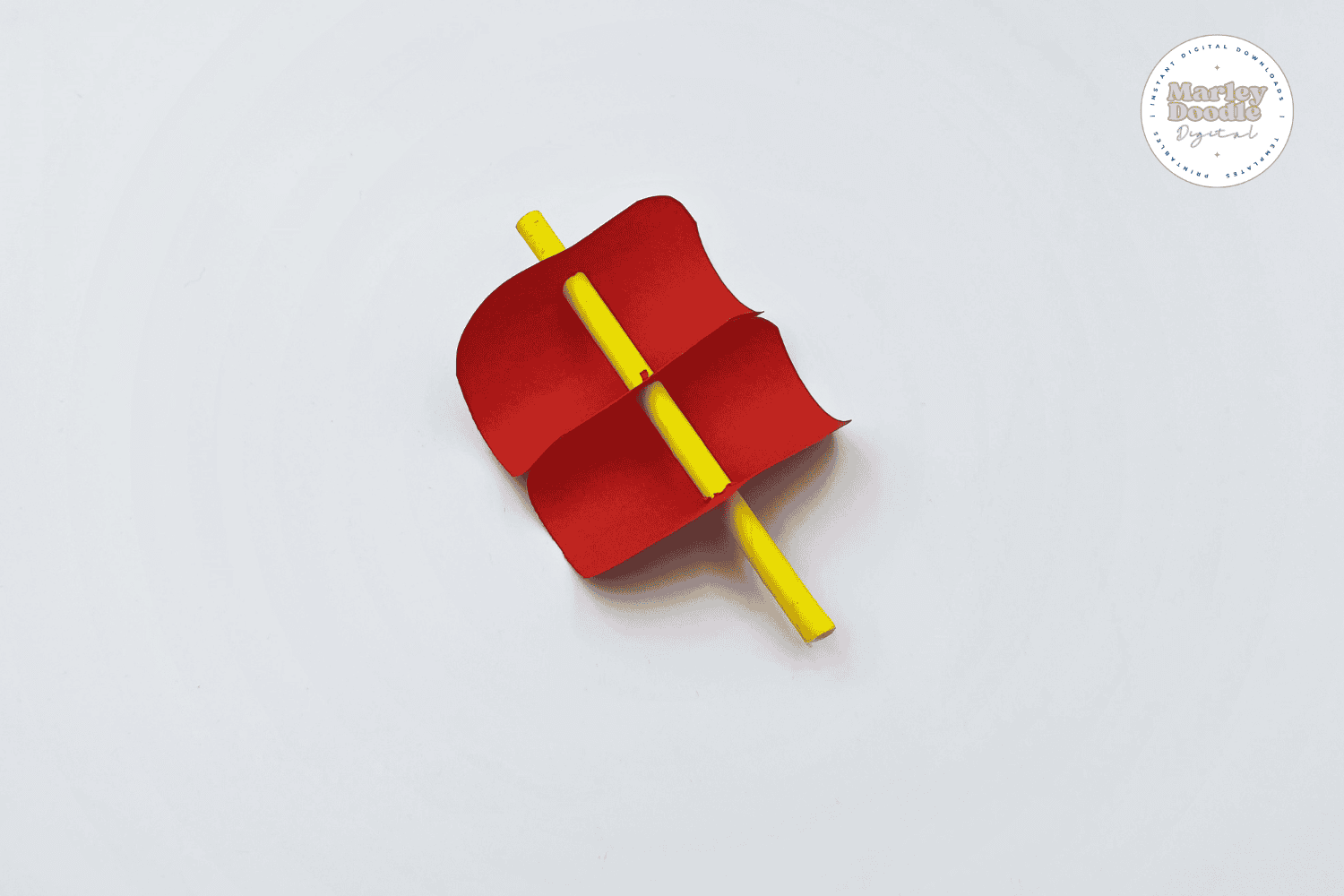 Red paper sails attached to a yellow paper straw.