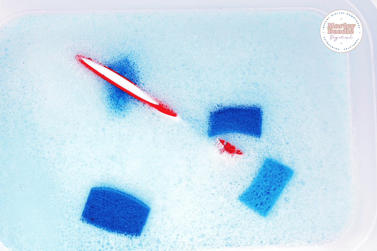 Soapy water bin with sponges and toothbrush for toy car wash activity.