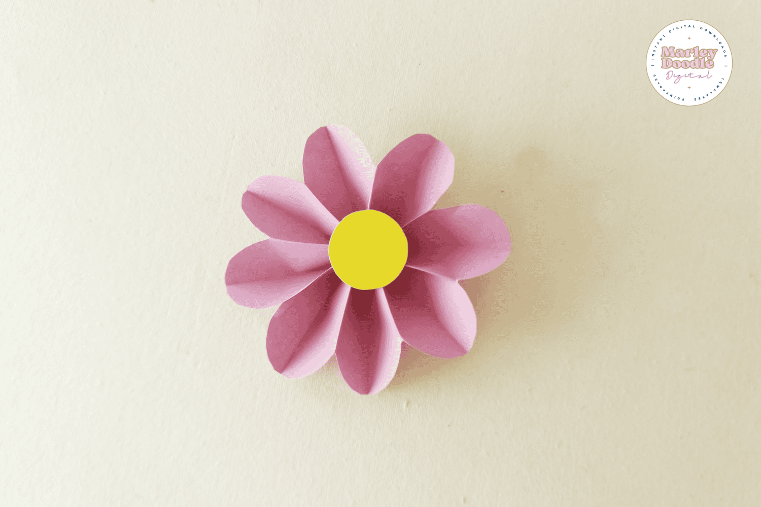 Completed pink paper flower with yellow center.