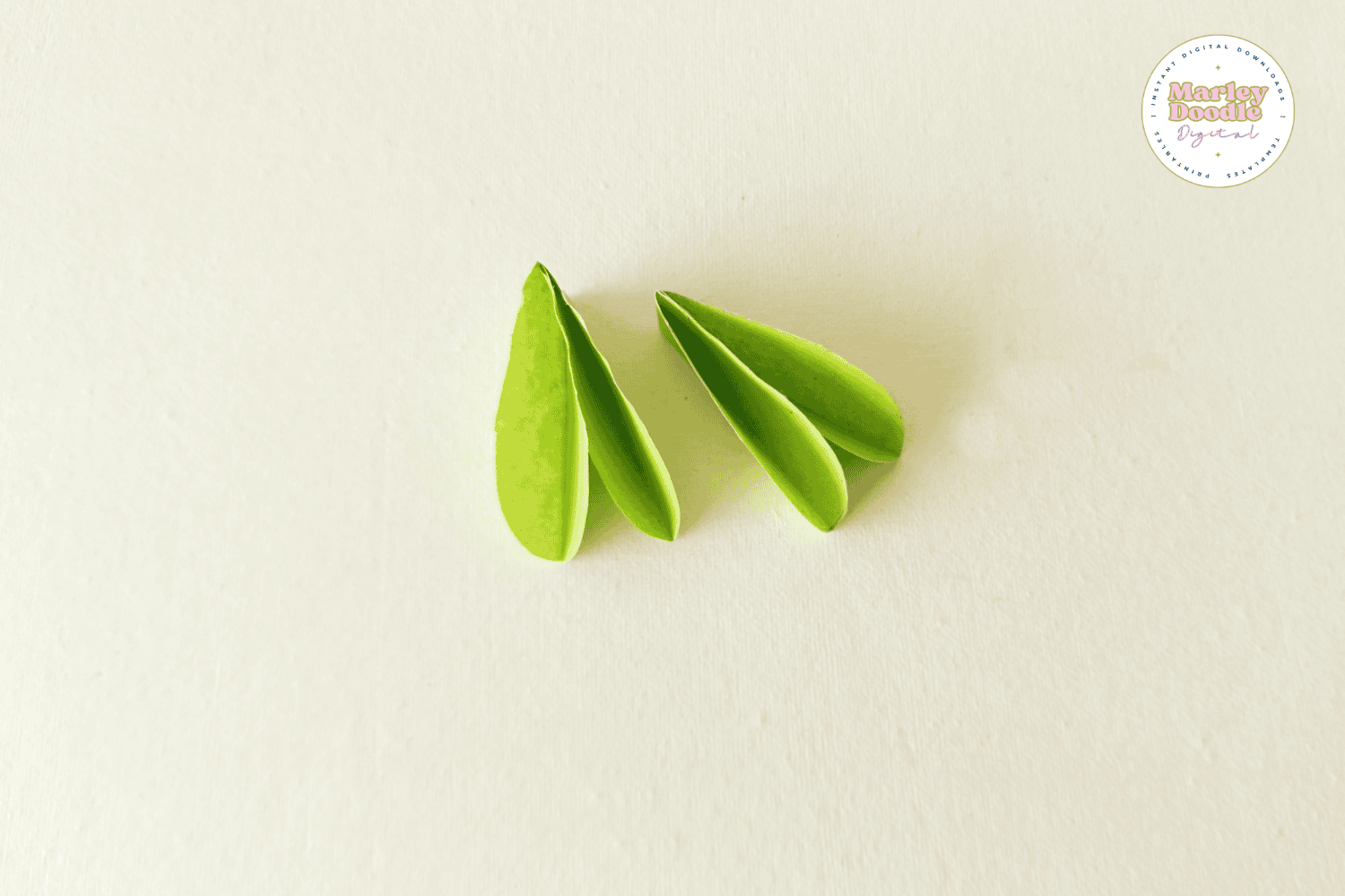 Two folded green paper leaves for flower wreath.