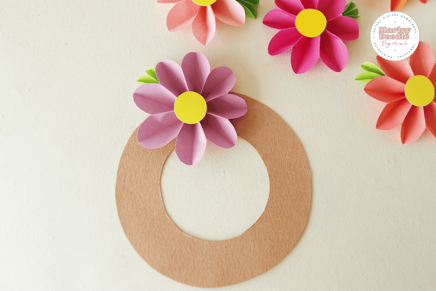 DIY paper flower wreath with pink and purple blooms on a cardboard ring.