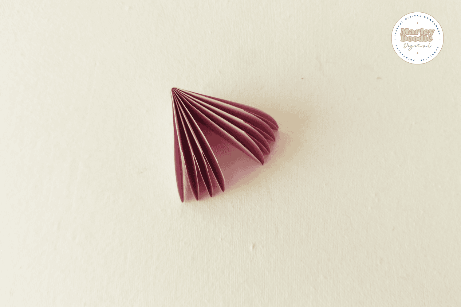 Fan shape formed from folded pink paper petals.