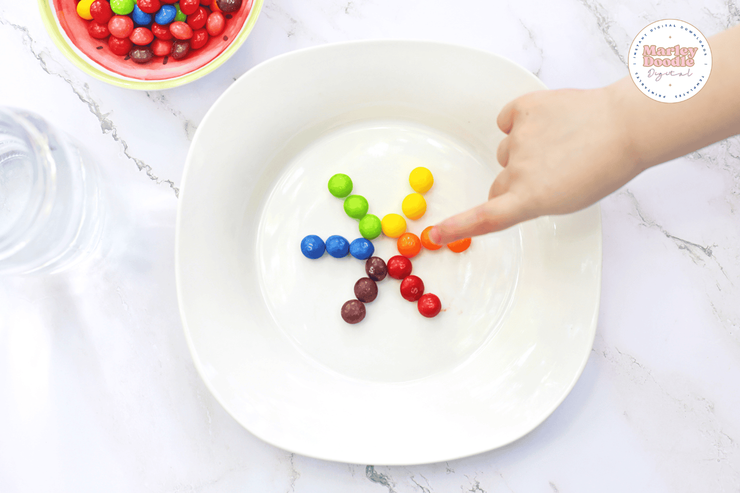 Child pointing to Skittles setup for color experiment