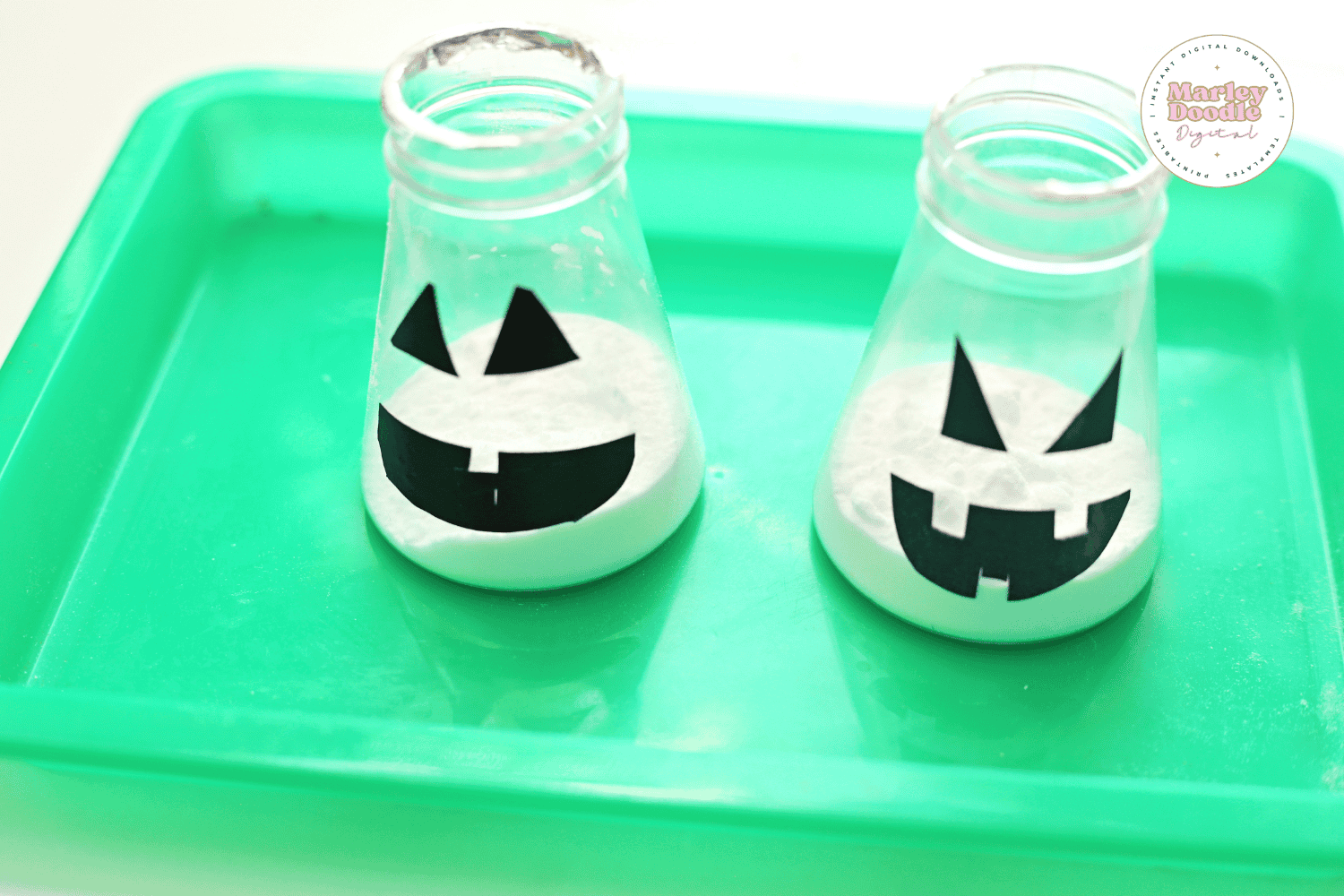 Plastic Jack-o-Lantern bottles filled with baking soda for Halloween potion experiment.