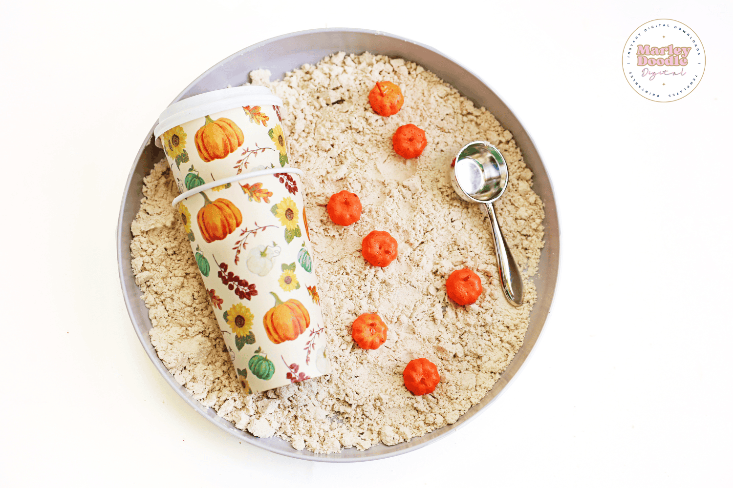 Pumpkin sensory bin with scoop and fall-themed cups